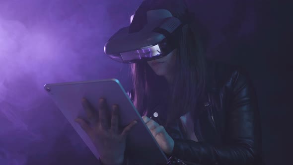 Unrecognizable woman in VR glasses browsing tablet