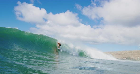 Surfer riding epic ocean wave getting barreled