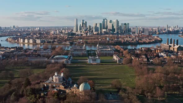 Dolly forward aerial drone shot of Greenwich observatory university towards Canary wharf skyscrapers