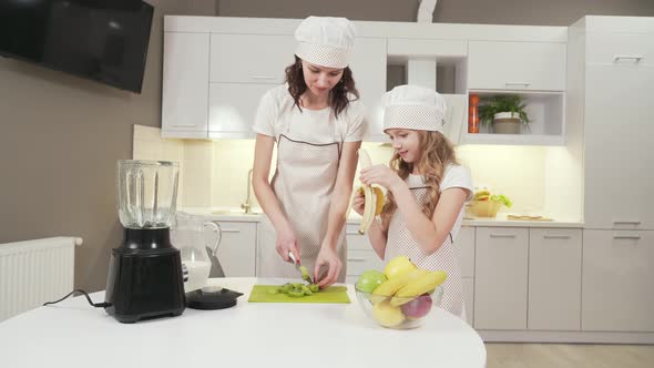 Attractive Woman and Little Girl Cutting Fruits for Cocktail