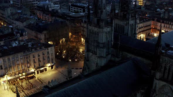 Bordeaux France St. Andrew Cathedral towers and roof at night with illuminated streets below, Aerial