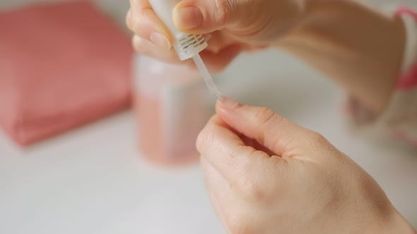 A Woman Does Her Own Manicure on Her Hands at Home