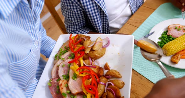 woman serving meal to man on dining table