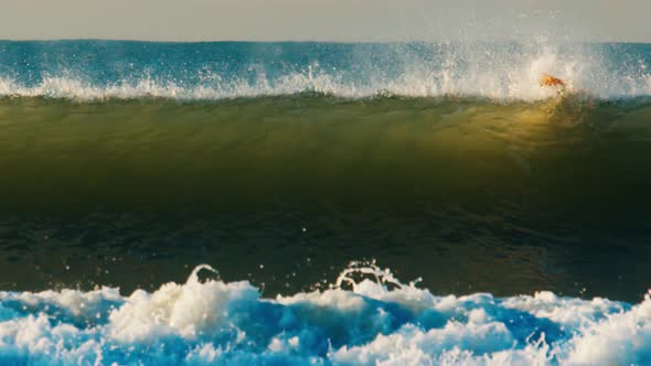 Ocean Wave Breaks on the Shore During Sunrise