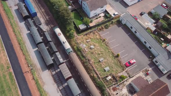 Stationary top down aerial shot of a vintage Diesel engine pulling passenger carriages through a 3 t