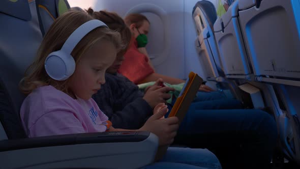 Sleeping Mother and Kids with Gadgets Traveling By Plane