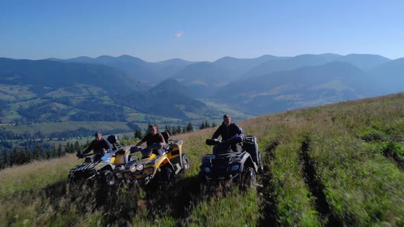 ATV Riders on Grassy Mountain Hill in Summer