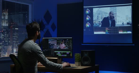 Young Man Sitting Back and Editing Video Inside a Room