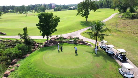 4K Aerial view group of Asian people golfing on at golf course in summer sunny day.