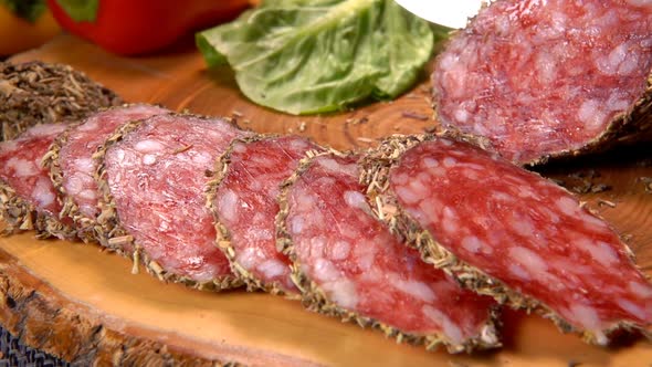 Sharp Knife Cut a Slice of Dried Sausage in Herbs