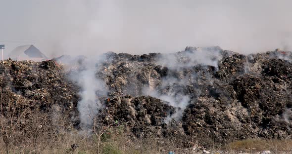 Close up of landfill with burning trash piles