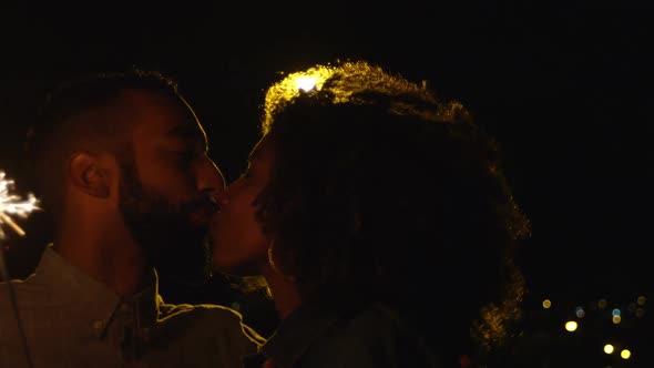 Couple kissing each other while holding sparkles in city 4k