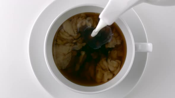 Pouring milk into a cup of coffee, Slow Motion