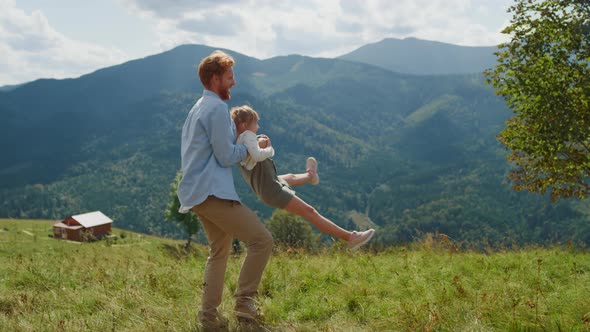 Father Having Fun Circling Daughter on Meadow