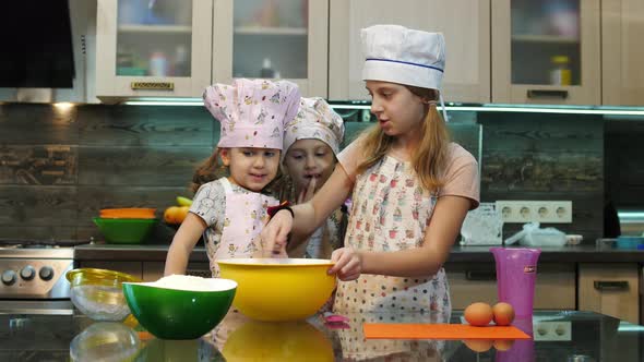 Three girls mixing ingredients in a bowl