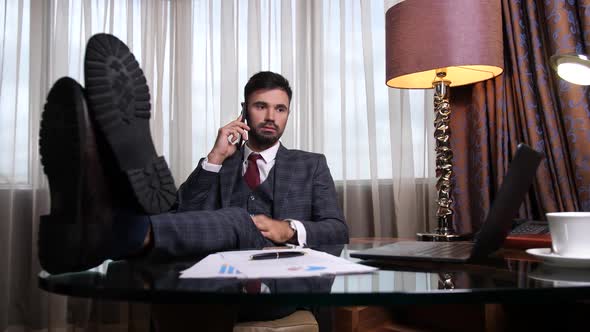 Businessman Talking on Phone During Break at Work