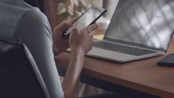 Close up hands typing mobile phone and scrolls through social media feed in a smartphone.