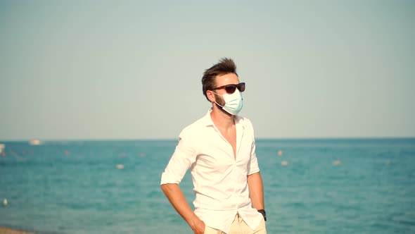 Sad Man In Face Mask At Covid Looking On Sea New Normal. Lockdown On Vacation.Covid-19 Pandemic