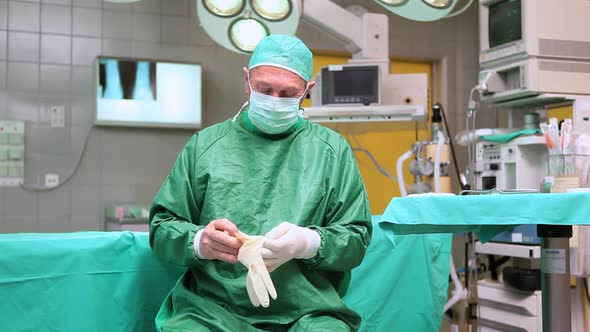 Surgeon putting on surgical gloves