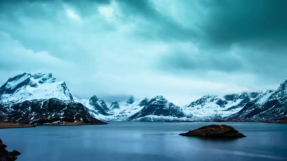 TIME LAPSE - Snowy mountain lake, Lofoten Islands, Norway, wide shot pan right