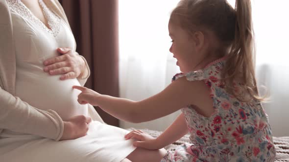 Pregnant Woman Feeling Happy at Home Taking Care of Child