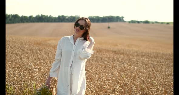 Beautiful Brown Hair Young Woman on Summer Wheat Field