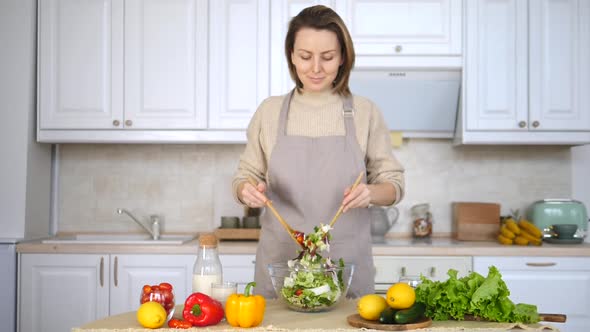 Young Smiling Woman Cooking Healthy Food In Kitchen Preparing Salad