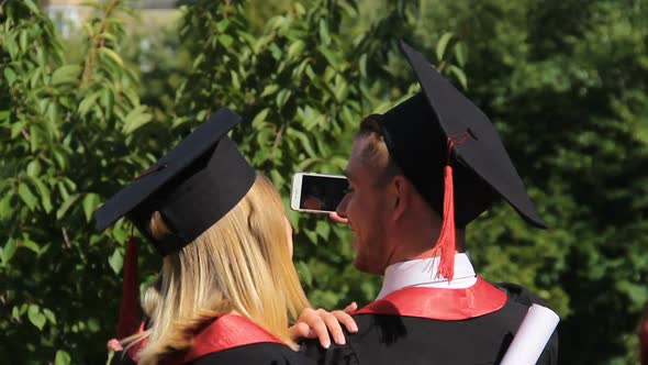 Couple of Joyful Graduates Recording Video on Smartphone, Graduation Ceremony