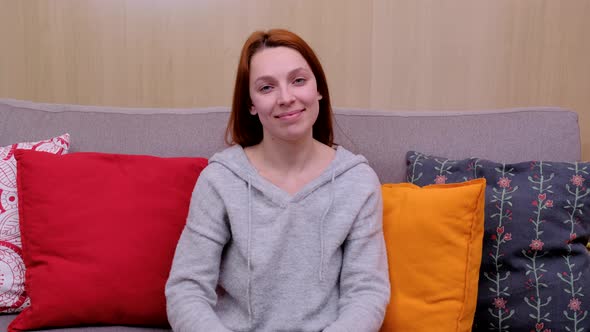 Happy Teen Girl Looking at Camera at Home, Cheerful Casual Young Woman with Funny Face Sit on Sofa