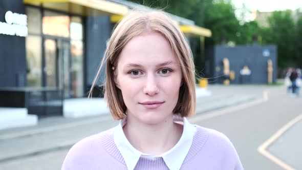 Cheerful Young Woman with Short Hair Waved By Light Wind