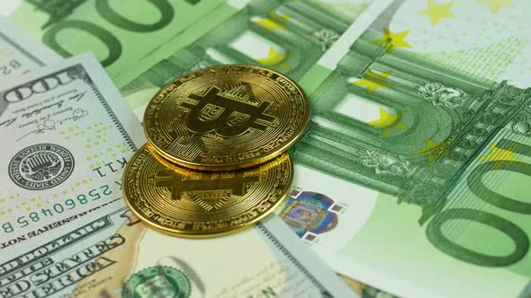 Close-up shot of bitcoin cryptocurrency on 100 dollar and euro bills rotate