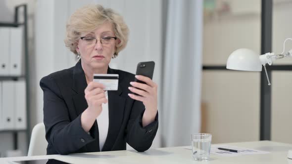 Old Businesswoman Excited By Online Shopping Success on Smartphone