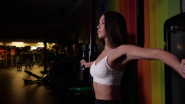 Brunette Girl Performs an Exercise for Muscles Bending and Flexing Her Arms