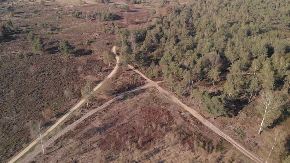 Crossing of roads in a moorland landscape seen from above backing off showing the wider trail patter