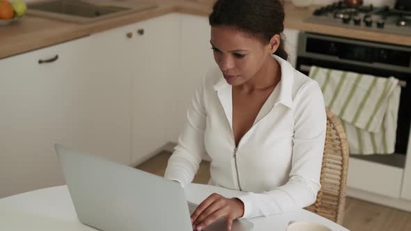 Concentrated African Woman working at laptop