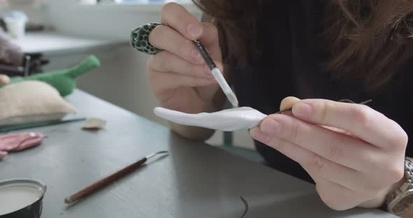 Woman Making Doll Ceramic Part Close Up. Female Sitting and Creating Ear for Doll at Home at Table