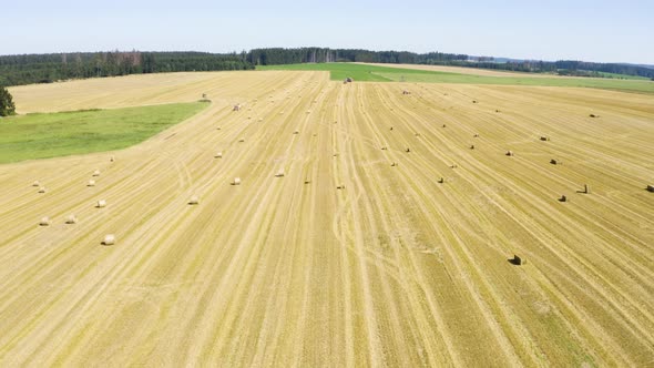 Aerial Drone Shot  a Field with Hay Bales in a Rural Area on a Sunny Day  Flies Across the Field