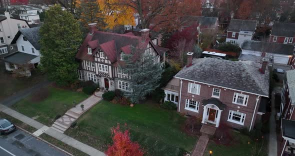 Aerial establishing shot of upscale expensive mansions in American suburb. Slow motion of car drivin