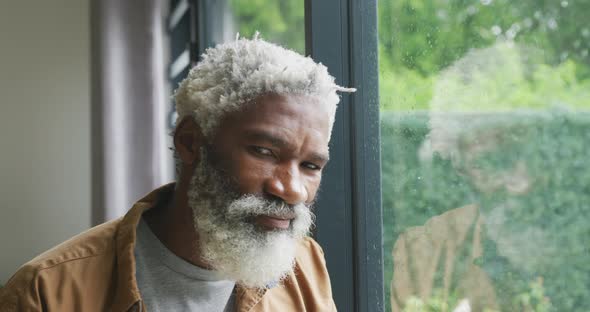 Video of happy african american senior man looking out the window