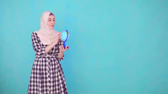 Young Beautiful Muslim Woman with Globe Model Looking