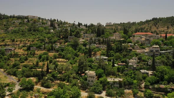 Village on a hill covered with forest, red roof tops, white buildings, arab village, Fly foreword, a