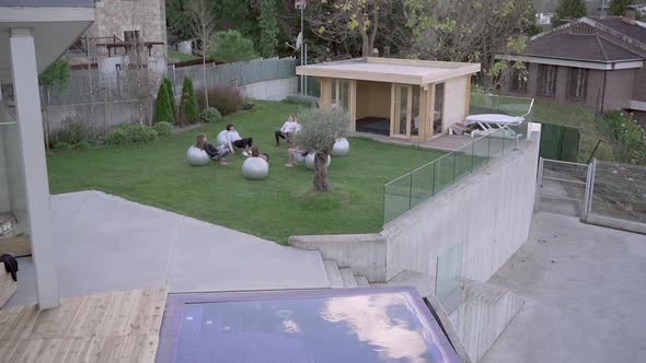 People doing yoga on fit balls together in backyard