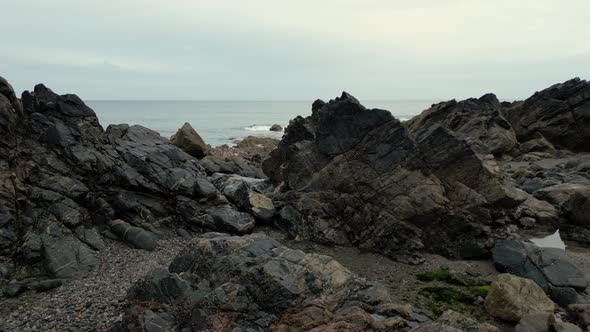 The rocky coastine at Kennack Sands, Cornwall, England gives way to a sandy beach in a popular holid