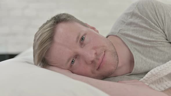 Man Smiling in Bed