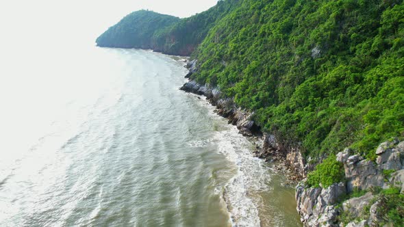 4K aerial view of mountain coast near beautiful beach and sea. Flight over sea.