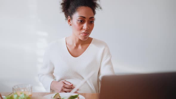 Cute African pregnant woman working on laptop