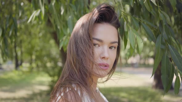 Portrait Charming Young Girl with Long Brunette Hair Wearing a Long White Summer Fashion Dress