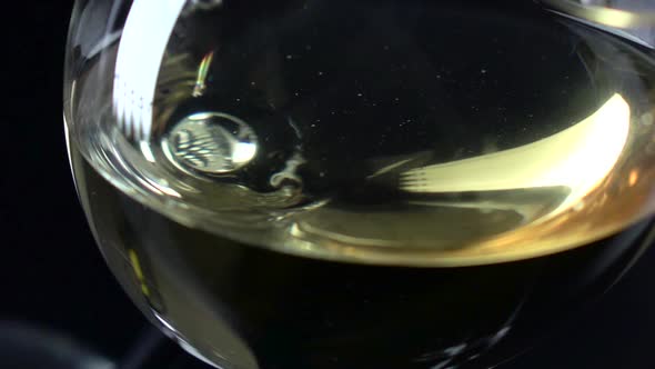 White Wine Being Poured Into a Wineglass, Glass Drops, Black, Slowmotion, Closeup