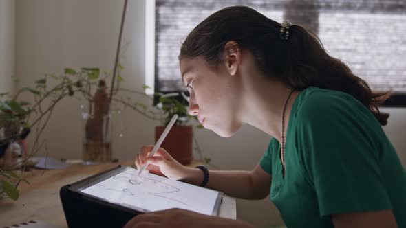 Teenage girl drawing using a tablet computer and an electronic pen