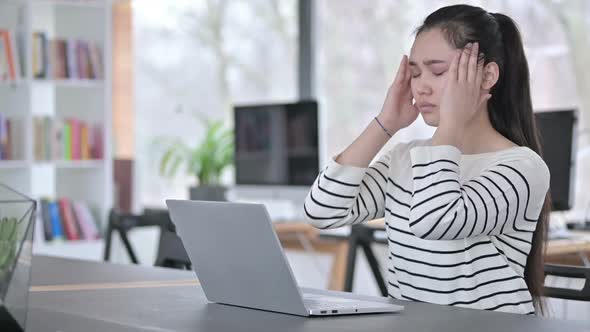 Laptop Use By Young Asian Woman with Headache in Office